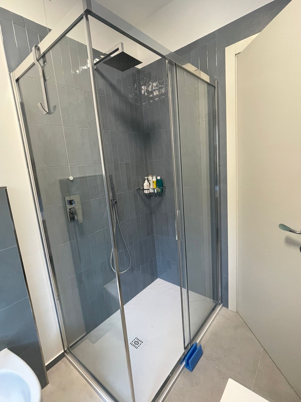 Interno box doccia con soffione quadrato a filo soffitto — rivestimento celeste Senigallia