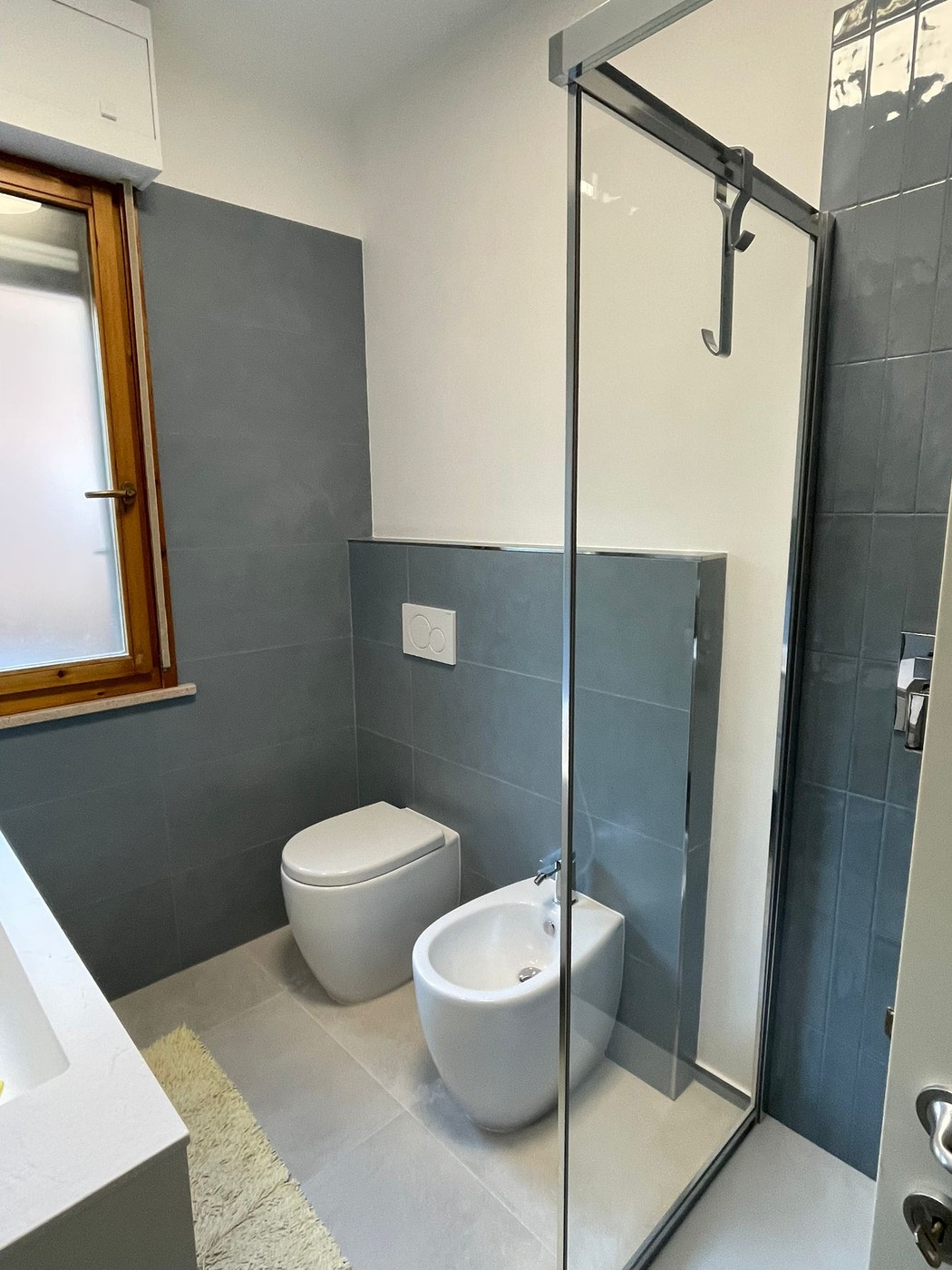 Bagno celeste: WC e bidet sospesi con box doccia scorrevole — Fratelli Venturi Senigallia 2025