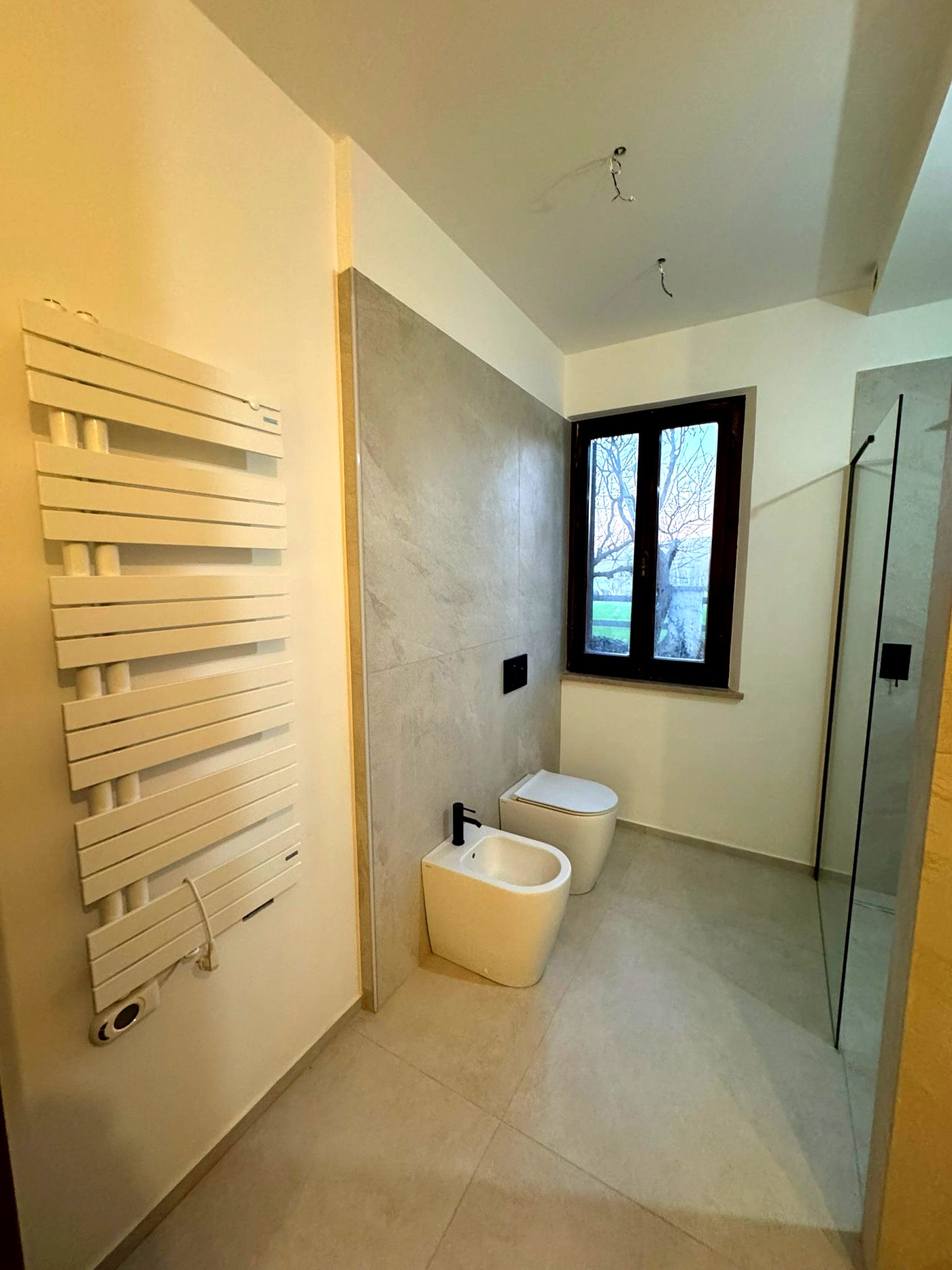 Bagno moderno con sanitari, scaldasalviette di design e box doccia — ristrutturazione Barbara 2026