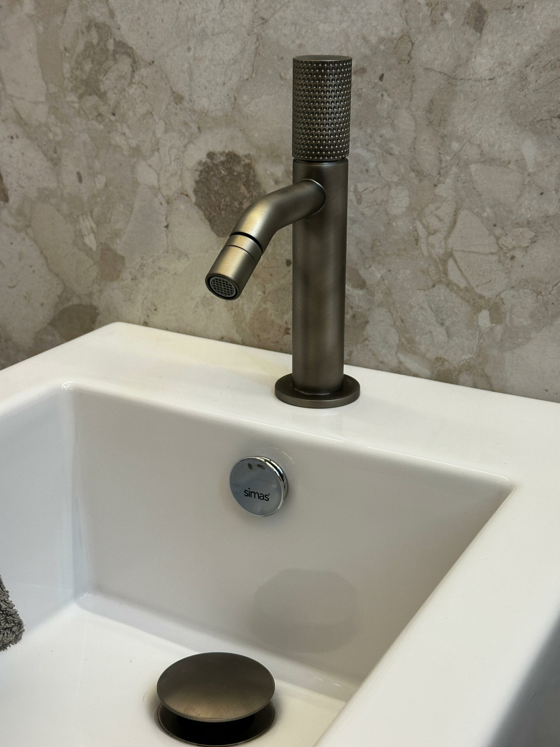 Dettaglio rubinetto Bongio ferro anticato con testa zigrinata su bidet Simas Frozen &mdash; finitura artigianale